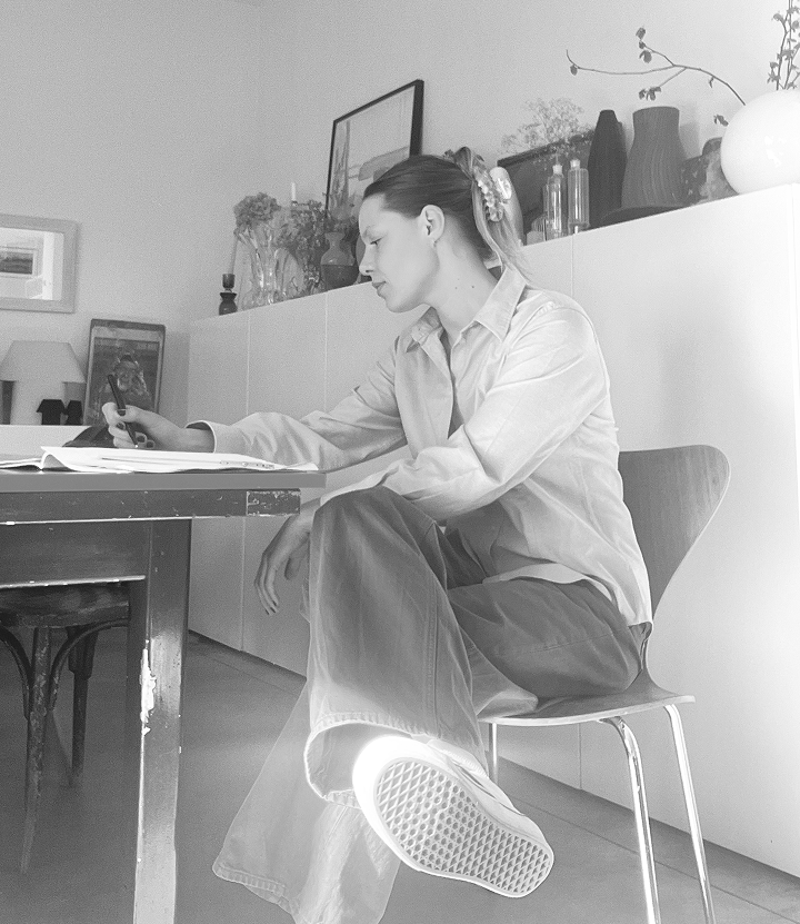 Lou en train de travailler sur un projet, assise derrière son bureau.